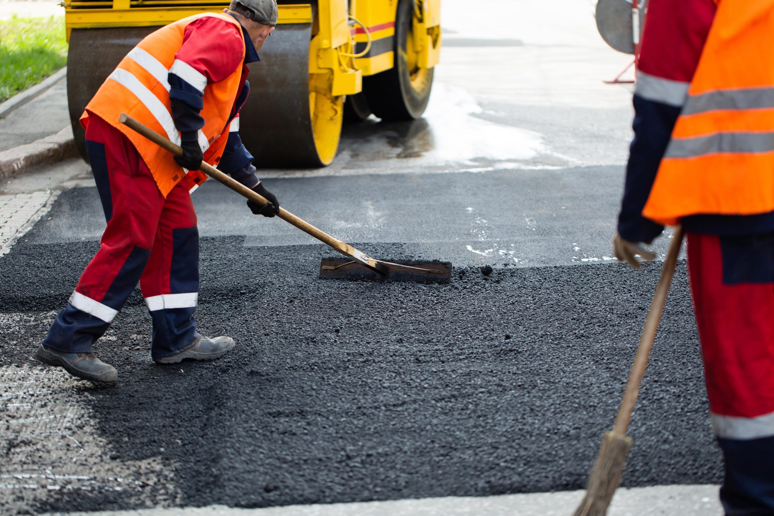 Straßenbauer bei der Arbeit mit temperaturabgesenktem Asphalt